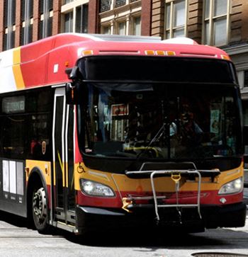 a bus driving down a street next to a tall building